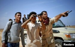 File - Libya Dawn fighters look at Islamic State militant positions near Sirte, Libya, March 2015.