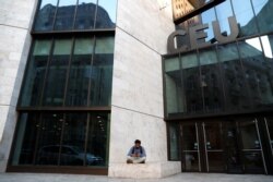 Seorang pria duduk di depan gedung Universitas Eropa Tengah, sebuah sekolah yang didirikan oleh pemodal AS George Soros, di Budapest, Hongaria, 9 April 2018. (Foto: Reuters)