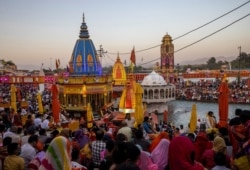 Devotees gather for an evening prayer on the banks of Ganges river during Kumbh Mela, or the Pitcher Festival, amidst the spread of the coronavirus disease (COVID-19), in Haridwar, India, April 10, 2021. REUTERS/Danish Siddiqui