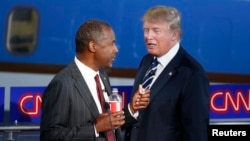 Kandidat calon presiden Partai Republik Ben Carson (kiri) dan Donald Trump, berbincang saat jeda iklan dalam debat presiden di CNN (16/9).