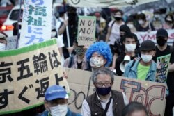 Orang-orang yang menentang Olimpiade Tokyo 2020, bersiap untuk melancarkan aksi protes di sekitar Stadion Nasional Tokyo, Minggu, 9 Mei 2021. (Foto AP / Eugene Hoshiko)