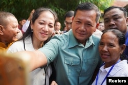 Hung Manet, putra sulung Perdana Menteri Kamboja Hun Sen, berswafoto bersama pendukungnya di sebuah TPS di Pnom Penh, Kamboja, Minggu, 23 Juli 2023. (Foto: Cindy Liu/Reuters)