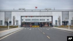 FILE - Police officers stand at the outer entrance of the Urumqi No. 3 Detention Center in Dabancheng in western China's Xinjiang Uyghur Autonomous Region, April 23, 2021.