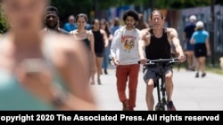 People go massless on the Atlanta Beltline on Friday, May 14, 2021, after the CDC updated their mask guidelines for vaccinated people. (AP Photo/Ben Gray)