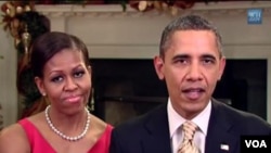 Ibu negara Michelle Obama mendampingi Presiden Barack Obama dalam pidato mingguan hari Sabtu (24/12).