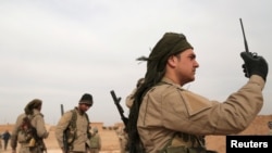 ARSIP - Seorang pejuang dari Syrian Democratic Forces (SDF) membawa sebuah walkie talkie seraya berdiri bersama rekan sesama pejuang dalam serangan melawan militan Islamic State di Raqqa, sebuah provinsi di bagian utara Suriah, 8 Februari 2017 (foto: REUTERS/Rodi Said)