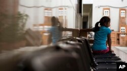 FILE - A Salvadoran migrant girl waits for her food at a migrant shelter in Guatemala City, July 12, 2019. 