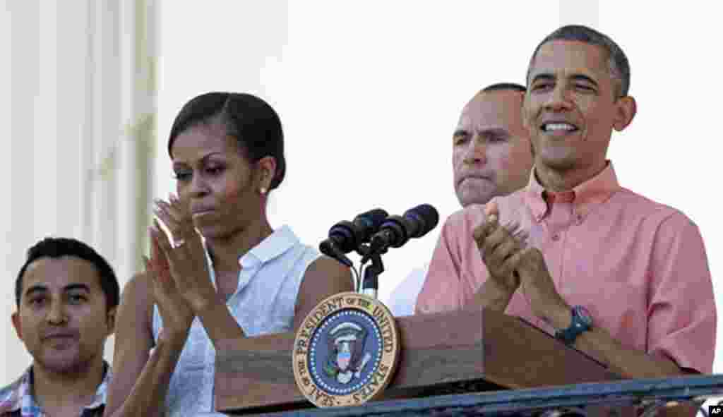 President Barack Obama and first lady Michelle Obama applaud during a Fourth of July celebration on the South Lawn of the White House, July 4, 2013.