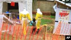 Petugas kesehatan menggandeng seorang anak yang diduga terpapar virus Ebola di perbatasan Uganda-Kongo (foto: ilustrasi). 