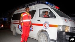 FILE - Medical workers wait by ambulances after a bomb attack at an ice cream shop in Mogadishu, Somalia, Nov. 27, 2020. 