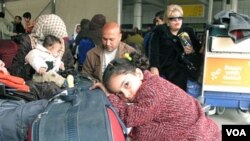 Para penumpang menunggu penerbangan di bandara Kairo sementara ribuan lainya siap meninggalkan Mesir, 1 Februari 2011.