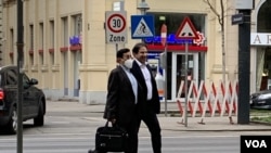 Dua anggota delegasi Iran sedang berjalan di Kota Wina, Austria, untuk persiapan pembicaraan mengenai kesepakatan nuklir antara Iran dan negara-negara Barat, Senin, 5 April 2021. (Foto: VOA Persian/Guita Aryan)