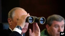 Presiden Rusia Vladimir Putin, kiri, dan Kepala Staf Umum Angkatan Bersenjata Rusia Valery Gerasimov, kanan, menyaksikan latihan militer di tempat latihan di Luzhsky Range, dekat St. Petersburg, Rusia. (Foto: via AP)