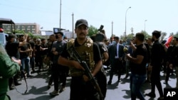Sejumlah anggota kelompok militan yang didukung Iran, berparade di pusat Kota Baghdad, Irak, pada 29 Juni 2021. (Foto: AP/Khalid Mohammed)