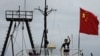 Captain Why Yang of Hong Kong fishing vessel "Kai Fung No.2" waves next to a Chinese national flag as he reaches in Hong Kong's island of Cheung Chau, August 22, 2012. 
