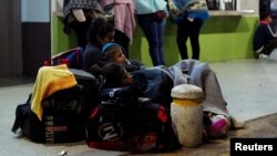 Venezuelan migrants rest with their luggage as they wait to register their entry into Ecuador, at the Rumichaca International Bridge, Ecuador, Aug. 9, 2018.