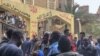 Sudanese refugees greet each other after Friday prayers in El-Barajil, a village on the outskirts of greater Cairo. (H. Elrasam/VOA)