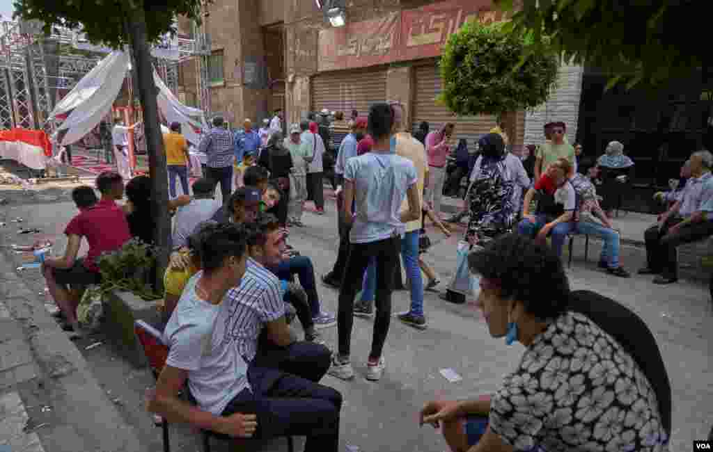 Some young men say "brokers" pay them to sit outside polls, presumably to create the appearance of greater youth participation in the election, in Cairo, Aug. 11, 2020.