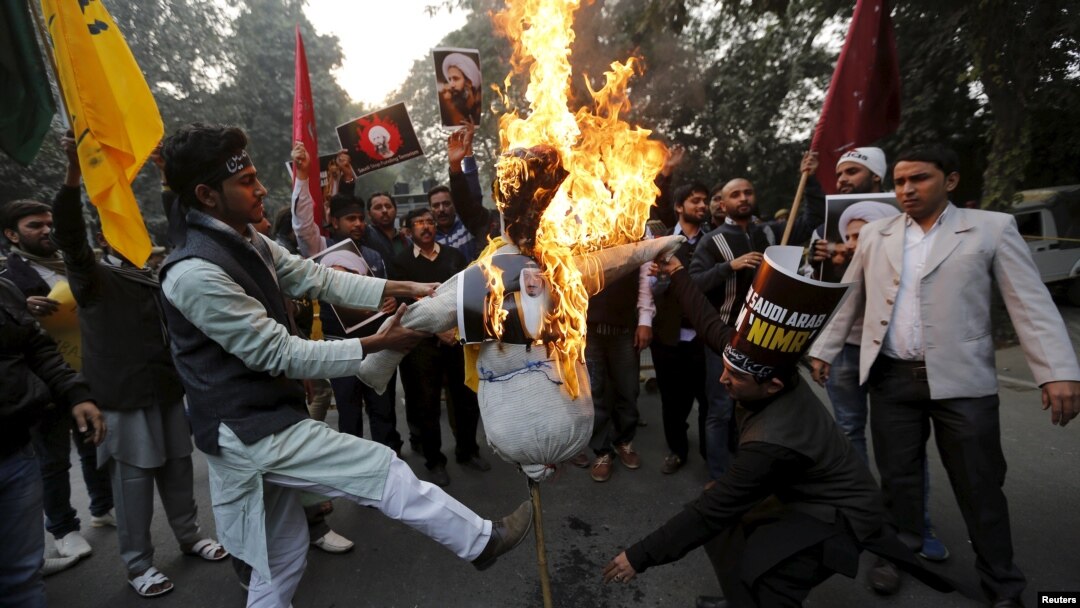 Shi'ite Muslims burn a representation of Saudi King Salman bin Abdulaziz during a protest against the execution in Saudi Arabia of cleric Nimr al-Nimr, in front of Saudi Arabia's embassy in New Delhi, India, Jan. 4, 2016.