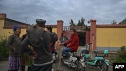 This photo taken on Sept. 13, 2019 shows people on a street in a small village where ethnic Uighurs live on the outskirts of Shayar in the region of Xinjiang.