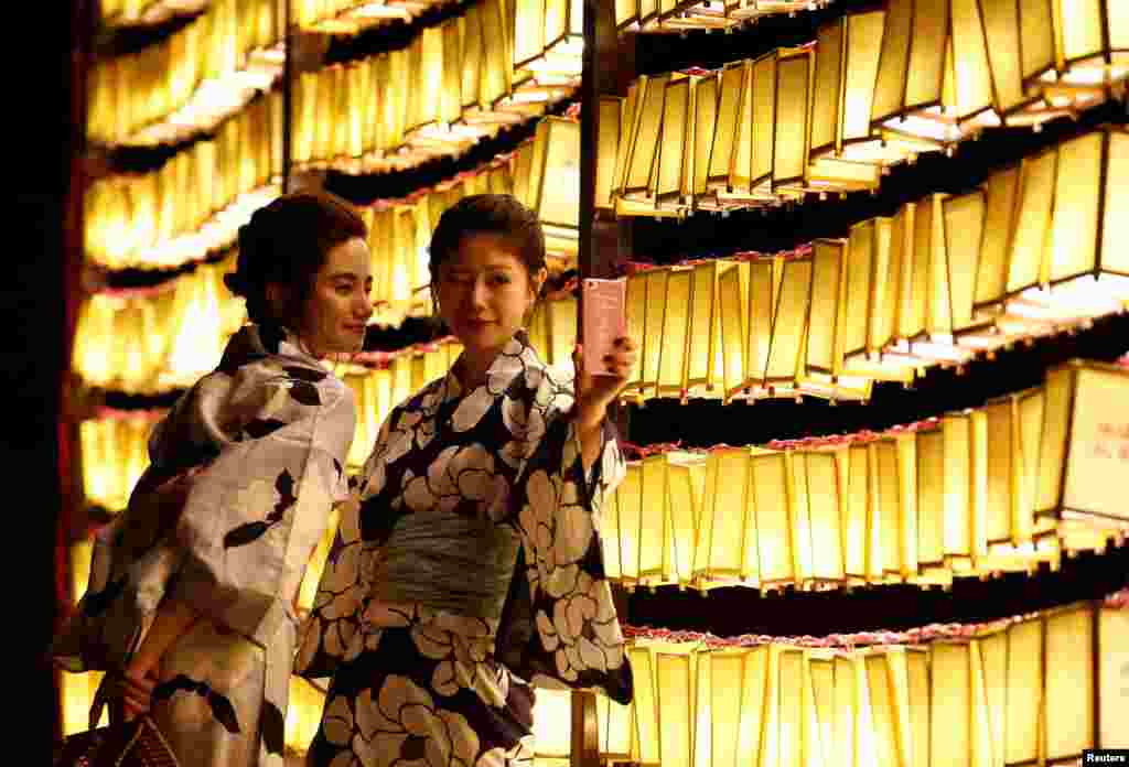 穿着夏季和服的女子在东京的灯笼前自拍(2017年7月13日)。