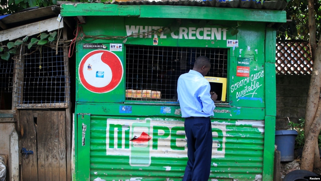 FILE - A customer conducts a transaction at a mobile money transfer stall in Nairobi, Kenya, Oct. 16, 2018. Due to the coronavirus crisis, millions of Africans rely on remittances more so than ever.