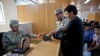 FILE - Afghan border police officers help a returnee scan fingerprints at the Afghanistan-Iranian border on the outskirts of Islam Qala in Herat province, west of Kabul, Afghanistan, April 13, 2015.