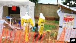 FILE - Health workers walk with a boy suspected of having contracted the Ebola virus, at an Ebola treatment center in Beni, DRC, Sept 9, 2018.