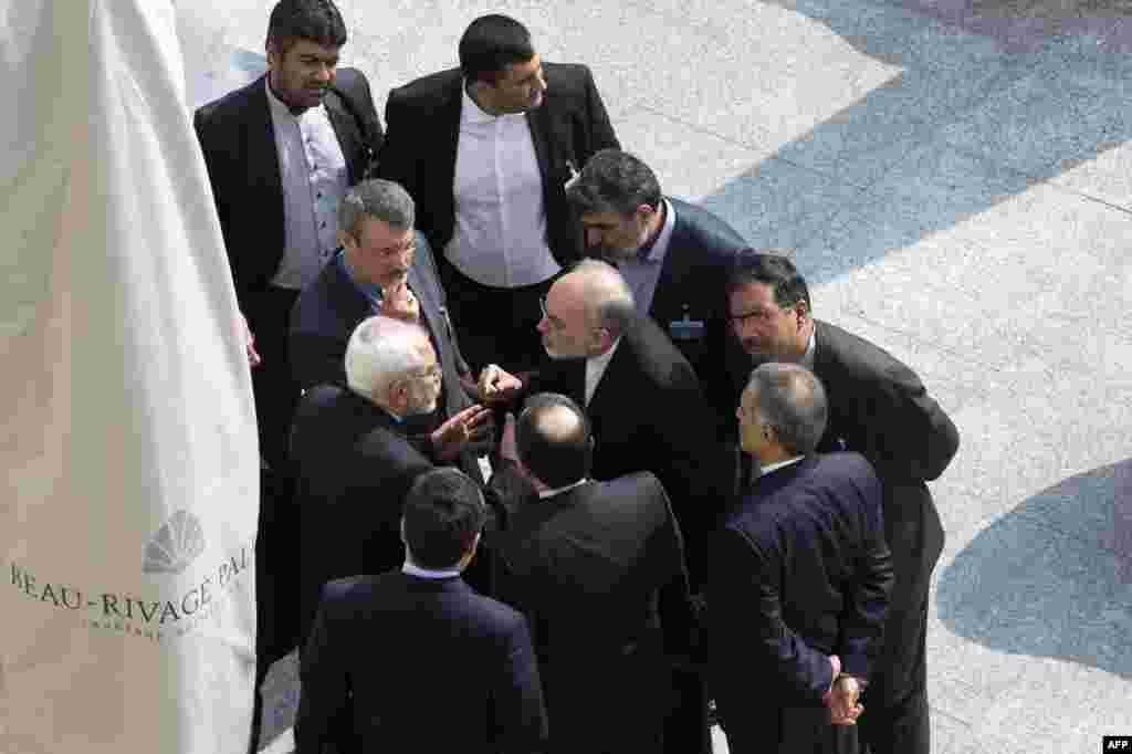 Menteri Luar Negeri Iran Mohammad Javad Zarif (kiri tengah) dan kepala Organisasi Energi Atom Iran Ali Akbar Salehi (kanan tengah) berbicara di luar bersama wakil mereka setelah sesi negosiasi pagi bersama Menteri Luar Negeri AS John Kerry tentang program nuklir Iran di in Lausanne, Swiss.