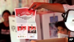 Para petugas pemilu melakukan perhitungan suara Pilpres di salah satu TPS di Jakarta, Rabu sore (17/4). (Foto: (AP/Tatan Syuflana)