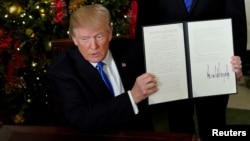 Predsednik Donald Tramp pokazuje uredbu nakon što je proglasio da SAD priznaju Jerusalim za glavni grad Izraela, u Beloj kući, 6. decembra 2017.