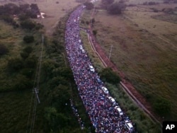 FILE - Members of a U.S.-bound migrant caravan cross a bridge between the Mexican states of Chiapas and Oaxaca after federal police briefly blocked them outside the town of Arriaga, Oct. 27, 2018.