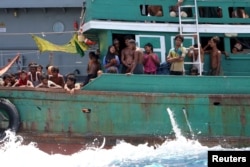 Some migrants despair after the Thai navy tows their boat away from Thailand, in waters near Koh Lipe island, May 16, 2015.