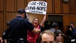 Salah seorang demonstran yang menentang pencalonan Brett Kavanaugh melakukan aksi unjuk rasa di Senat AS, Selasa (4/9).