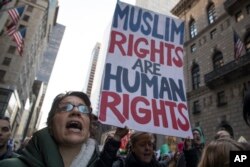 FILE - A demonstrator holds a sign during a rally outside Trump Tower in New York on Saturday, Nov. 12, 2016, to protest against President-elect Donald Trump.