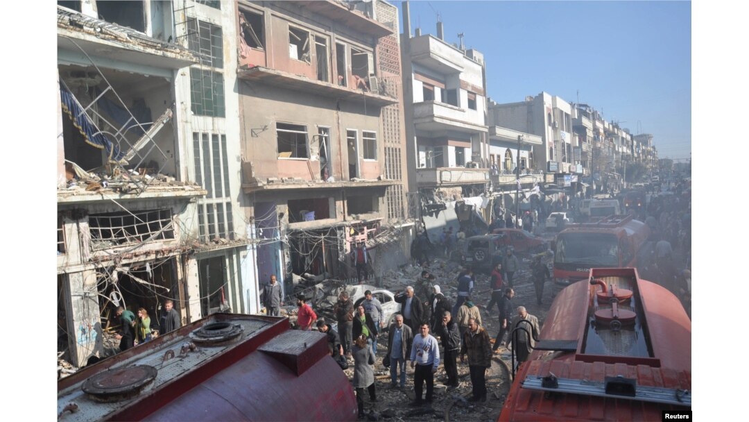 FILE - Syrian army soldiers and civilians inspect the site of two bombings in the Syrian city of Homs, in this photo provided by the state-owned Syrian Arab News Agency (SANA), Dec. 28, 2015.