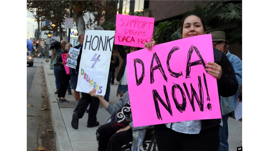 FILE - Demonstrators urging the Democratic Party to protect the Deferred Action for Childhood Arrivals program rally outside the office of California Democratic Sen. Dianne Feinstein in Los Angeles, Jan. 3, 2018.