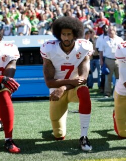 ARHIVA - Kvoterbek San Franciska Kolin Kapernik kleči tokom izvođenja američke himne pred početak utakmice protiv Sijetla, 25. septembra 2016. (Foto: AP/Ted S. Warren)