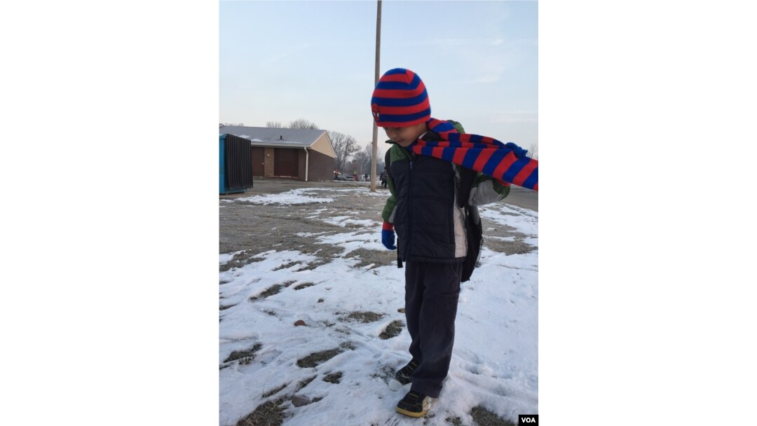 Bu Say Wah waits for his school bus to pick him up. The first-grader is learning English as well as his native language at his Fort Wayne school. His teachers say he is a star pupil and respectful. (C. Presutti/VOA)