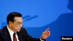 FILE - China's Premier Li Keqiang gestures at the end of a news conference following the closing ceremony of China's National People's Congress (NPC) at the Great Hall of the People in Beijing, China, March 16, 2016.