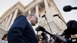 As a bitterly divided Congress moves toward a government shutdown, Senate Minority Leader Chuck Schumer, D-N.Y., center, speaks to the media outside the Capitol after meeting with President Donald Trump, Jan. 19, 2018, in Washington.