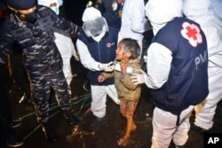 Tenaga medis membantu seorang gadis muda Rohingya setibanya di Pelabuhan Krueng Geukueh di Aceh Utara, 31 Desember 2021..(Foto: AP)