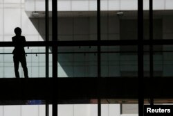 FILE- A woman talks on phone inside the Bank of China head office building in Beijing, China.