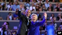 President Barack Obama and Democratic Presidential candidate Hillary Clinton wave together during the third day of the Democratic National Convention in Philadelphia , July 27, 2016.