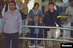 Former Peruvian President Alberto Fujimori, center, accompanied by his son Kenji Fujimori, right, leaves the Centenario hospital in Lima, Peru, Jan. 4, 2018.