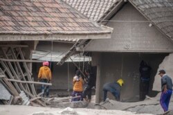 Petugas penyelamat melakukan pencarian warga di daerah yang tertutup abu vulkanik di Desa Sumber Wuluh di Lumajang pada 5 Desember 2021, setelah letusan Gunung Semeru yang menewaskan sedikitnya 13 orang. (Foto: AFP/Juni Kriswanto)