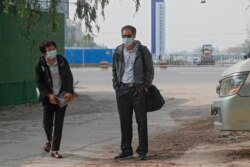 北京公益志愿者陈玫的母亲（左）和北京公益志愿者蔡伟的父亲为旁听他们儿子的庭审到达北京一家法院外。(2021年5月11日)