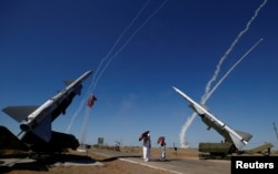 People watch S-300 air defense missile systems launching missiles during the Keys to the Sky competition.
