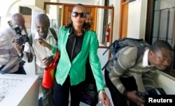 FILE - Kenyan marathon runner Rita Jeptoo walks past photographers as she arrives at the Athletics Kenya headquarters after failing a doping test, in Kenya's capital Nairobi, January 15, 2015.