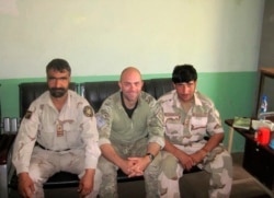 Perwira Pasukan Khusus AS Ryan Brummond, tengah, duduk di sebelah Mohammad Khalid Wardak, kanan, di Afghanistan. (Foto: AP/Ryan Brummond)